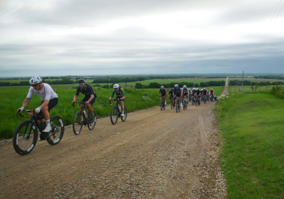 Peloton stretched along a gravel road in the Kansas prairie