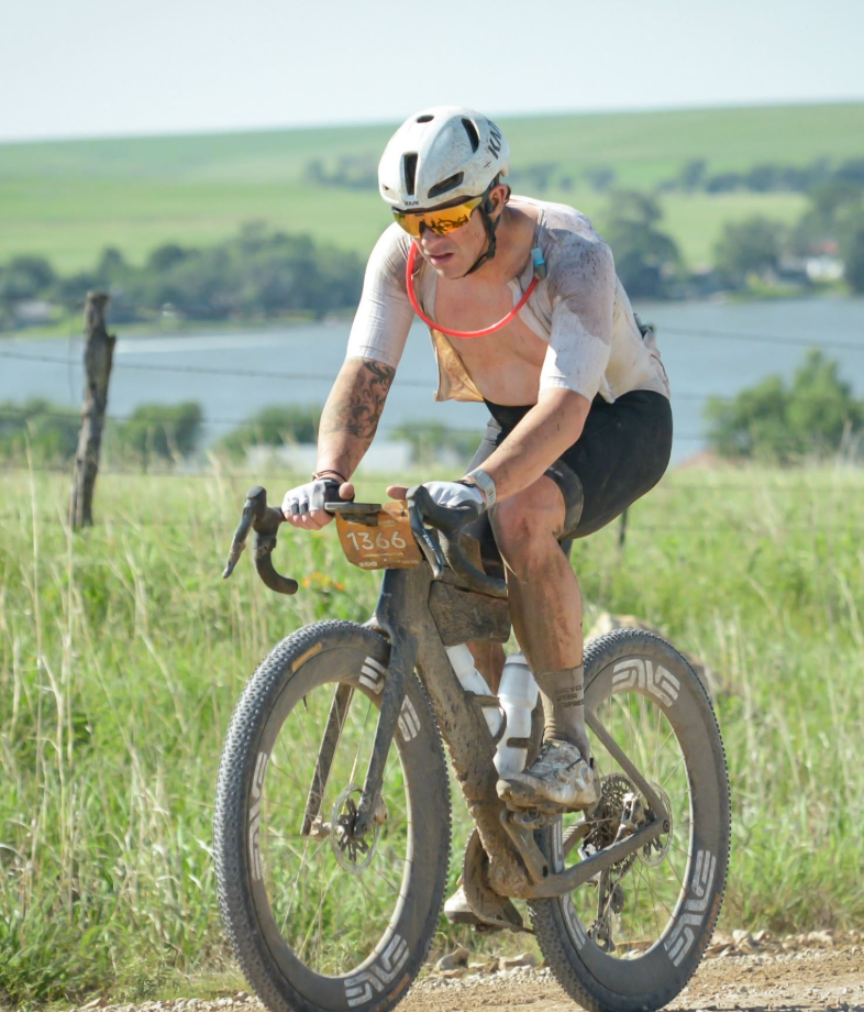 Solo rider grinding through the Flint Hills with a reservoir behind